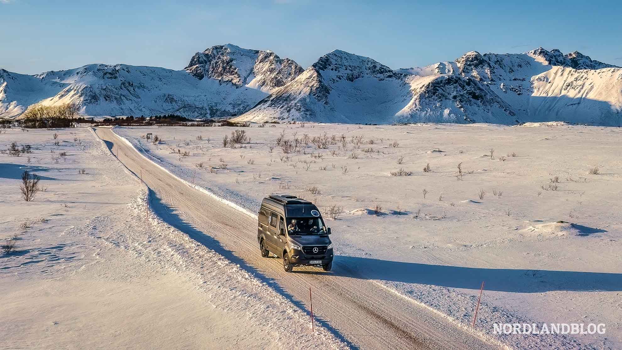 Wintercamping in Norwegen Kastenwagen auf verschneiter Strasse