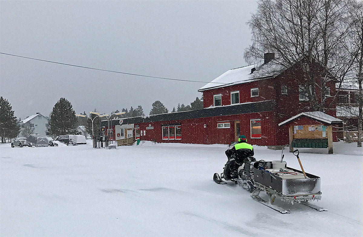 Schneescooter auf dem Weg zur Tankstelle im Dorf (Norwegen).